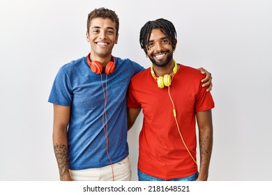 Young Hispanic Brothers Standing Over Isolated Background Wearing Headphones With A Happy And Cool Smile On Face. Lucky Person. 