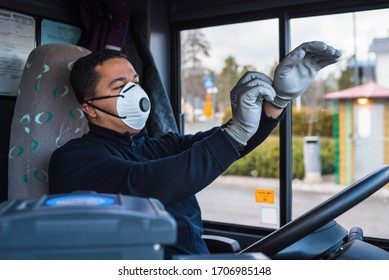 Young Hispanic Bus Driver With Mask Puts Protecting Gloves On His Hand In Bus To Protect Himself From The Coronavirus Epidemic. Covid 19. Protect From Corona Virus. Quarantine 2020. Stay Home.
