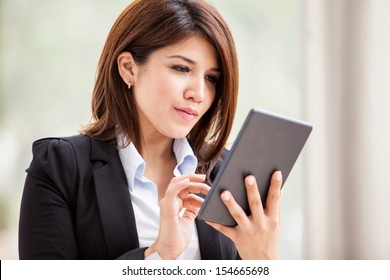 Young Hispanic Business Woman Using A Tablet To Check Her Emails