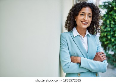 Young Hispanic Business Woman Wearing Professional Look Smiling Confident At The City Leaning On The Wall