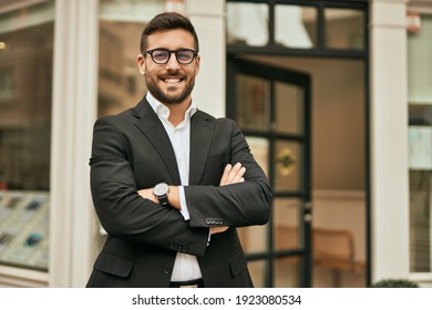 Young hispanic businessman with arms crossed smiling happy at the city. - Shutterstock ID 1923080534