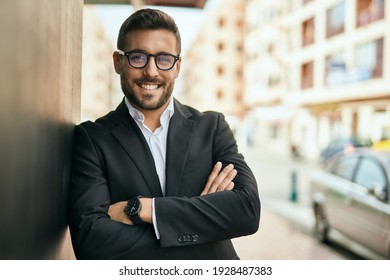 Young hispanic businessman with arms crossed smiling happy at the city.