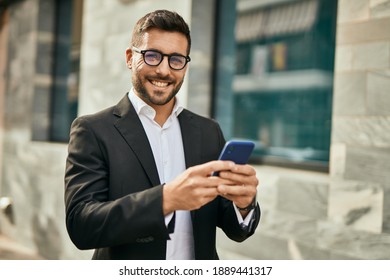 Young hispanic businessman smiling happy using smartphone at the city.