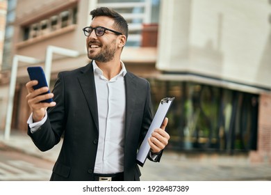 Young hispanic businessman smiling happy using smartphone at the city.