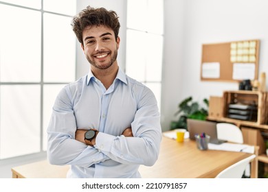 Young hispanic businessman smiling happy standing with arms crossed gesture at the office. - Powered by Shutterstock