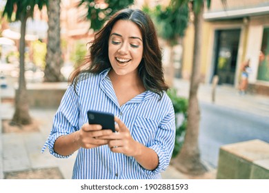 Young hispanic businesswoman smiling happy using smartphone at the city. - Shutterstock ID 1902881593