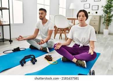 Young Hispanic Couple Doing Yoga At Home