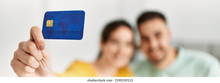 Young Hispanic Couple Holding Credit Card At Home.