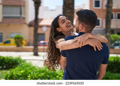 Young hispanic couple smiling confident hugging each other at park - Powered by Shutterstock