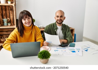 Young Hispanic Couple Smiling Happy Using Laptop Sitting On The Table At Home.