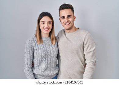 Young Hispanic Couple Standing Over White Background With A Happy And Cool Smile On Face. Lucky Person. 