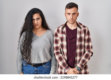 Young Hispanic Couple Standing Over White Background Skeptic And Nervous, Frowning Upset Because Of Problem. Negative Person. 