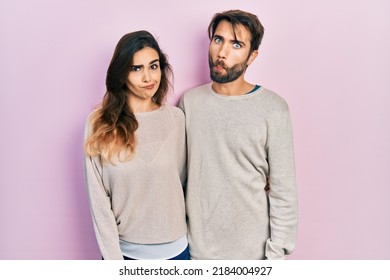 Young Hispanic Couple Wearing Casual Clothes Making Fish Face With Lips, Crazy And Comical Gesture. Funny Expression. 