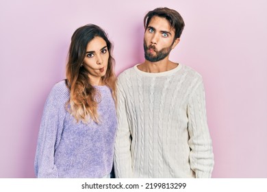 Young Hispanic Couple Wearing Casual Clothes Making Fish Face With Lips, Crazy And Comical Gesture. Funny Expression. 