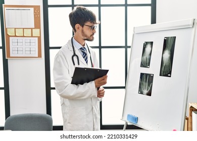 Young Hispanic Doctor Man Looking Xray Working At Clinic