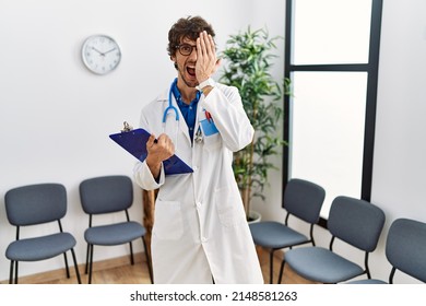 Young Hispanic Doctor Man At Waiting Room Covering One Eye With Hand, Confident Smile On Face And Surprise Emotion. 