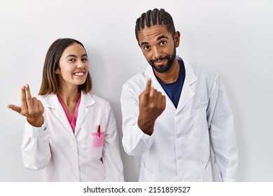 Young Hispanic Doctors Standing Over White Background Beckoning Come Here Gesture With Hand Inviting Welcoming Happy And Smiling 