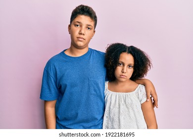 Young Hispanic Family Of Brother And Sister Wearing Casual Clothes Together Relaxed With Serious Expression On Face. Simple And Natural Looking At The Camera. 