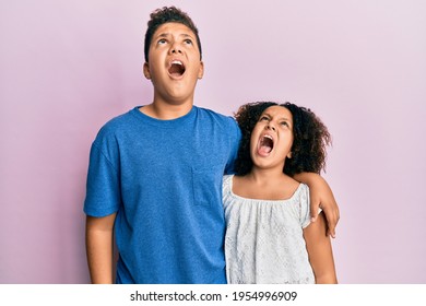 Young Hispanic Family Of Brother And Sister Wearing Casual Clothes Together Angry And Mad Screaming Frustrated And Furious, Shouting With Anger. Rage And Aggressive Concept. 