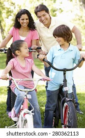 Young Hispanic Family Cycling In Park