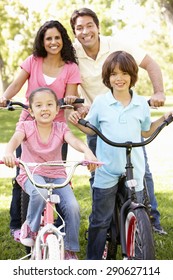 Young Hispanic Family Cycling In Park