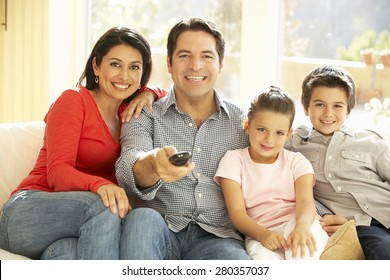 Young Hispanic Family Watching TV At Home