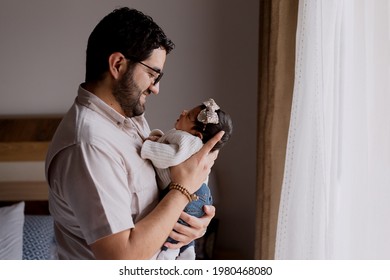 Young Hispanic Father Holding His Newborn Baby At Home - New Father Smiling With His Baby In His Arms