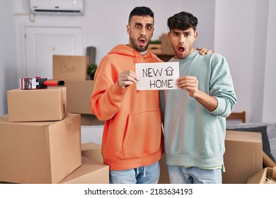 Young Hispanic Gay Couple Moving To A New Home In Shock Face, Looking Skeptical And Sarcastic, Surprised With Open Mouth 