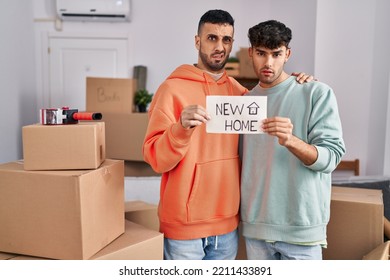 Young Hispanic Gay Couple Moving To A New Home Clueless And Confused Expression. Doubt Concept. 