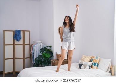 Young Hispanic Girl Dancing On Bed At Bedroom