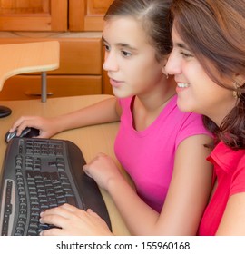 Young Hispanic Girl And Her Beautiful Mother Working On A Desktop Computer