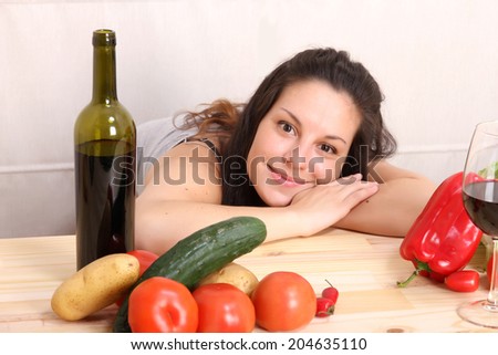 A young hispanic girl in the kitchen between vegetables.
