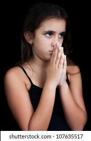 Young Hispanic Girl Praying Isolated On Black