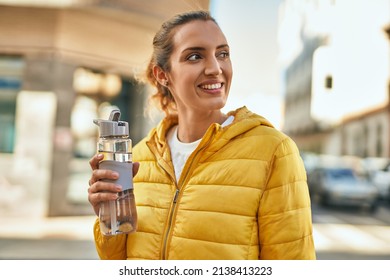 Young Hispanic Girl Smiling Happy Drinking Bottle Of Water At The City.