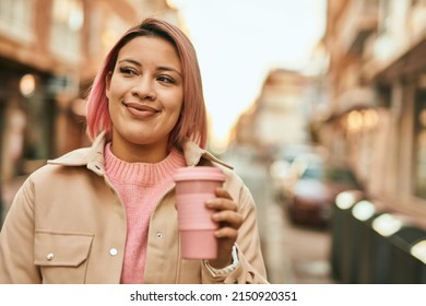 Young hispanic girl smiling happy drinking coffee at the city.