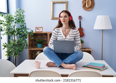 Young Hispanic Girl Using Laptop At Home Thinking Attitude And Sober Expression Looking Self Confident 