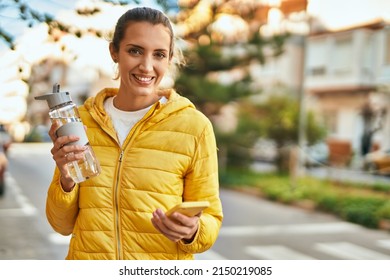 Young Hispanic Girl Using Smartphone And Drinking Water At The City.