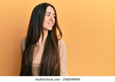 Young Hispanic Girl Wearing Casual Clothes Looking To Side, Relax Profile Pose With Natural Face And Confident Smile. 