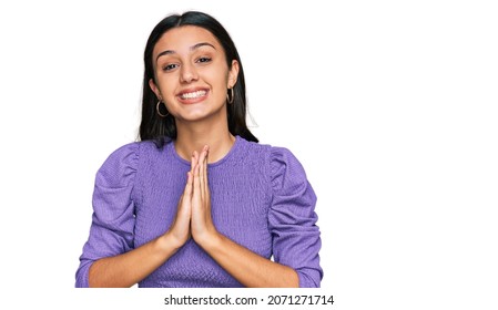 Young Hispanic Girl Wearing Casual Clothes Praying With Hands Together Asking For Forgiveness Smiling Confident. 