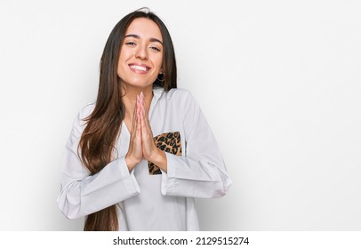 Young Hispanic Girl Wearing Casual Clothes Praying With Hands Together Asking For Forgiveness Smiling Confident. 