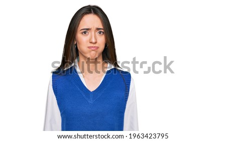 Young hispanic girl wearing casual clothes puffing cheeks with funny face. mouth inflated with air, crazy expression. 