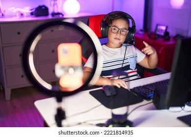 Young Hispanic Kid Playing Video Games Smiling Happy Pointing With Hand And Finger To The Side 