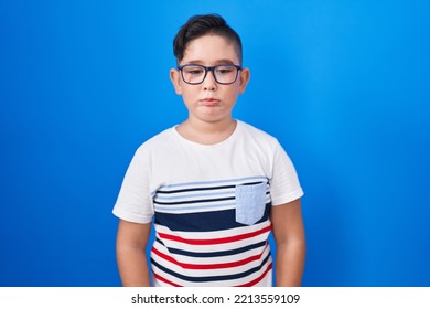 Young Hispanic Kid Standing Over Blue Background Depressed And Worry For Distress, Crying Angry And Afraid. Sad Expression. 