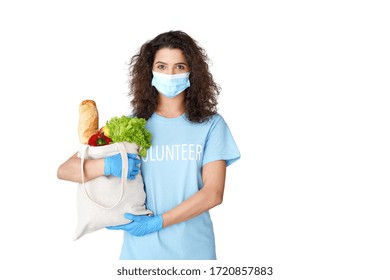 Young Hispanic Latin Girl Courier Wears Volunteer Tshirt, Medical Face Mask, Gloves Look At Camera Holding Eco Bag Deliver Food Delivery Donation Stand Isolated On White Studio Background. Portrait.