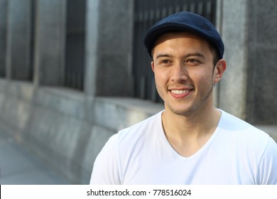 Young Hispanic male smiling outside looking away