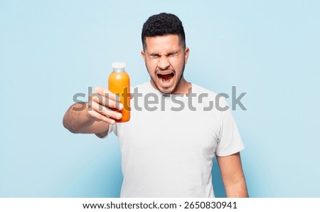 young hispanic man angry expression and holding a smoothy
