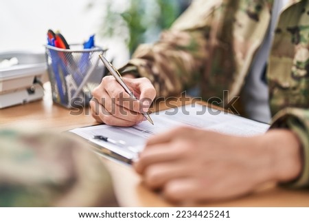 Young hispanic man army soldier signing contract at office
