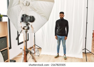 Young Hispanic Man With Beard Posing As Model At Photography Studio Skeptic And Nervous, Frowning Upset Because Of Problem. Negative Person. 