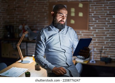 Young Hispanic Man With Beard And Tattoos Working At The Office At Night Depressed And Worry For Distress, Crying Angry And Afraid. Sad Expression. 