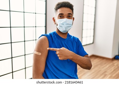 Young Hispanic Man With Beard Wearing Safety Mask Getting Vaccine Smiling Happy Pointing With Hand And Finger 